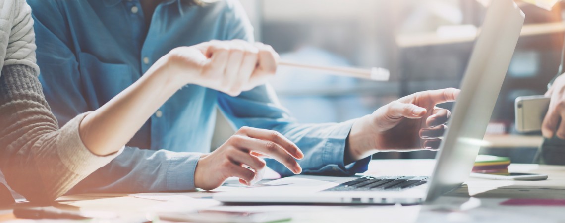 Imagem principal do site -  desmostra um homem e uma mulher discutindo questões importantes relacionadas ao trabalha, a mulher aponta um lápis para tela do notebook.